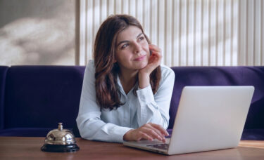 Gestora analisando demanda previsível na hotelaria pelo notebook para reduzir os efeitos da sazonalidade